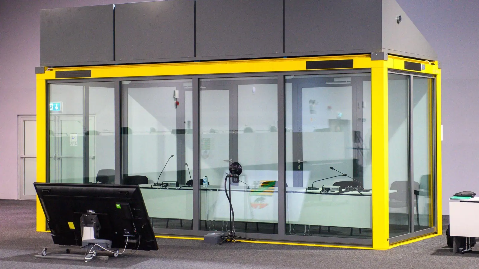 Blick auf den leeren Glaskasten im Gerichtssaal des temporären Gerichtsgebäudes vom Landgericht Magdeburg, in dem normalerweise der Todesfahrer vom Magdeburger Weihnachtsmarkt sitzt. (Foto: Klaus-Dietmar Gabbert/dpa)