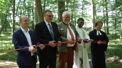 Oberbürgermeister Dr. Markus Naser, Creglingens Bürgermeister Uwe Hehn, Ruheforst-Geschäftsführer Jost Arnold und die beiden Pfarrer Arulraj Antony und Tilman Staak (von links) schnitten gemeinsam das Band zur Erweiterung des Ruheforstes durch. (Foto: Anna Beigel)