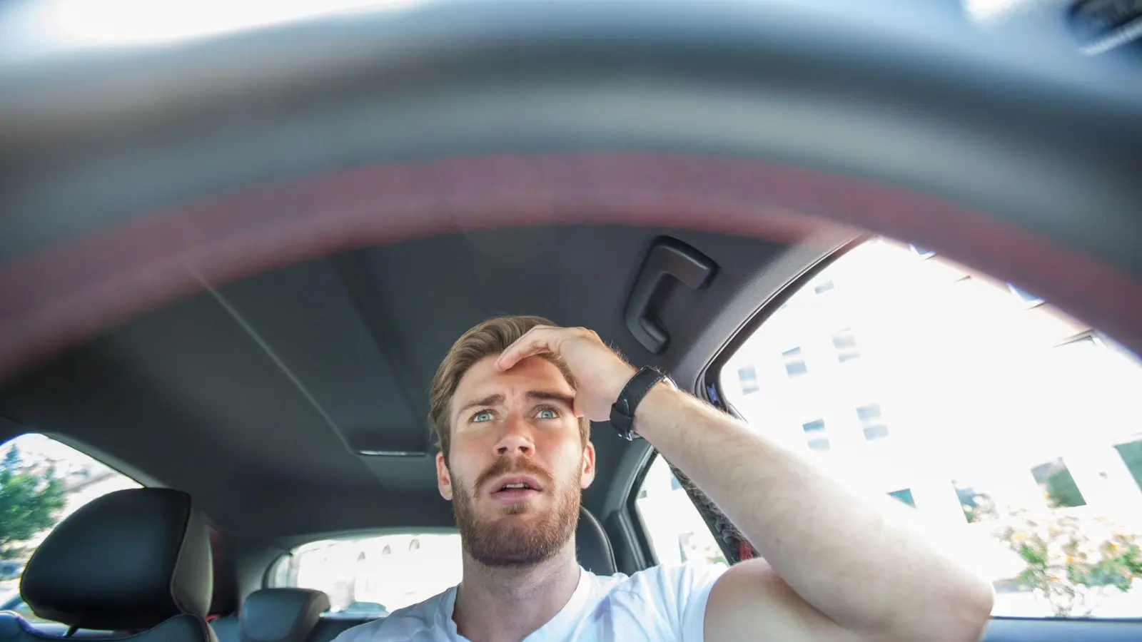 Ein Mann erschreckt sich beim Autofahren. Vielleicht durch den Aufschrei des Beifahrers oder weil ein Assistenzsystem plötzlich lospiept. In solchen Situationen heißt es: Ruhe bewahren. (Foto: Christin Klose/dpa-tmn)