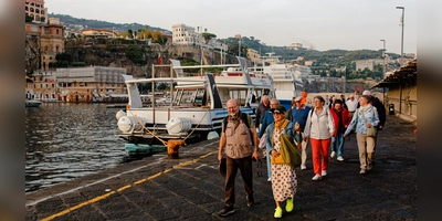 Die Reiseleiterin Viktoria Laszlo führt die Reisenden entlang des Hafens der Halbinsel zu deren Fähre. Viele der Fahrten in Richtung Neapel oder Capri werden hier mit dem Schiff gemacht, da Landwege oft zu lange dauern. (Foto: Tizian Gerbing)