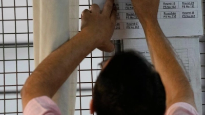 Ein Wahlhelfer markiert eine Tabelle nach der ersten Runde der Stimmenauszählung in einem Auszählungszentrum in Neu-Delhi. (Foto: Manish Swarup/AP/dpa)