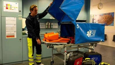 Patienten werden auf der Transporttrage vor neugierigen Blicken geschützt. (Foto: Lennart Preiss/dpa)