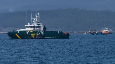 Schiffe der Guardia Civil und des Zolls beteiligen sich an der Bergung eines mutmaßlichen Drogen-U-Boots, von dem nur eine Spitze aus dem Wasser ragt. (Foto: Elena Fernandez/ZUMA Press Wire/dpa)