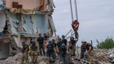 Rettungskräfte durchsuchen die Trümmer eines Wohnblocks in Tschassiw Jar, der von einer russischen Rakete getroffen wurde. (Foto: Nariman El-Mofty/AP/dpa)