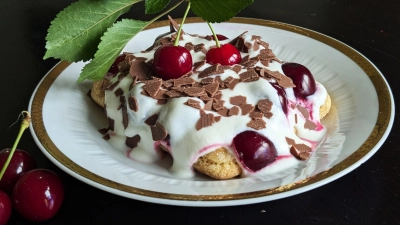 Auf die mit Espresso getränkten Löffelbiskuits kommen eine Quark-Sahne-Masse und reichlich Kirschen. Das Tiramisu wird mit Schokoraspeln getoppt.   (Foto: Doreen Hassek/hauptstadtkueche.blogspot.com/dpa-tmn)