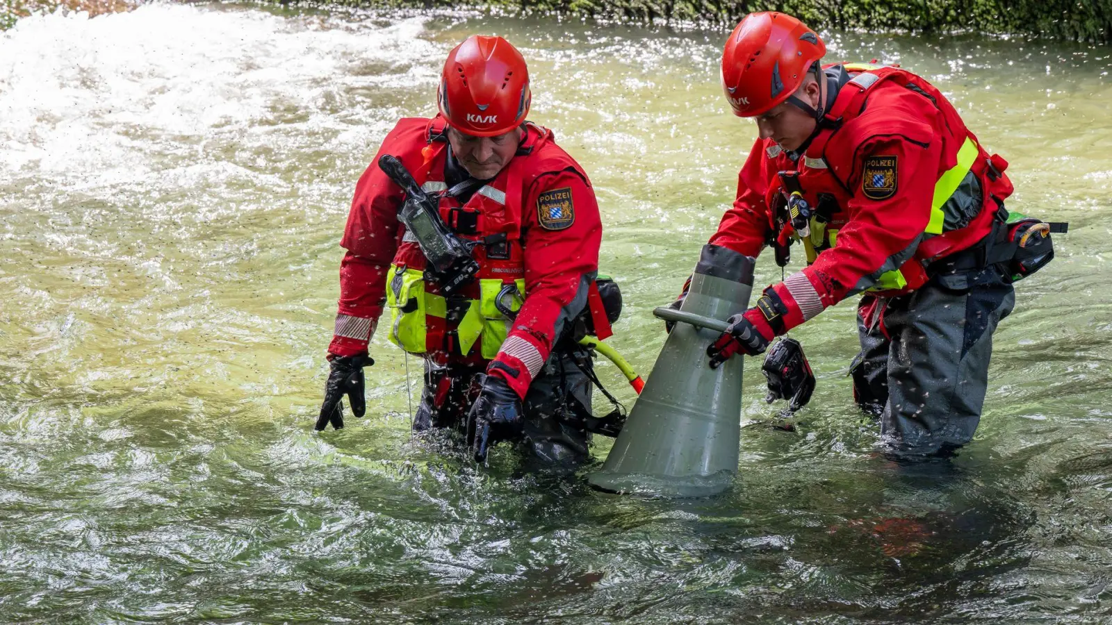 Polizeitaucher untersuche mit einem Schauglas den Boden des Eisbachs.  (Foto: Peter Kneffel/dpa)