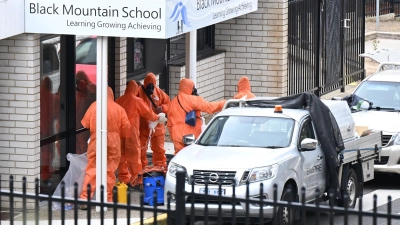 In Schutzanzügen wurden die Schulen gesäubert und der Sand entsorgt. (Foto: Lukas Coch/AAP/dpa)