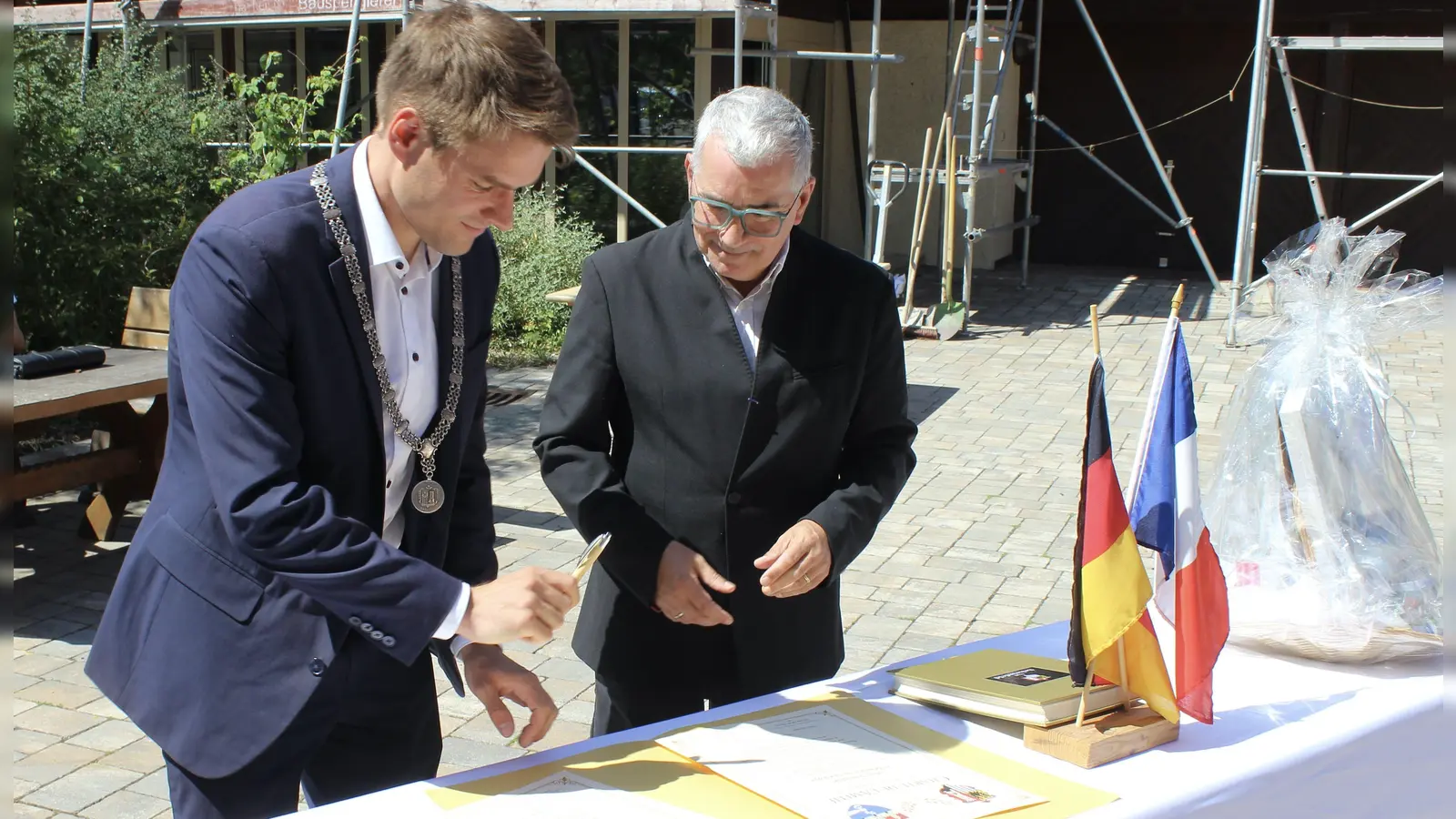 Scheinfelds Bürgermeister Theodor Schell (links) und Frédéric Le Hech als Vertreter Beaulieus unterzeichneten im Innenhof von Kloster Schwarzenberg eine Urkunde zur Bekräftigung der Städtepartnerschaft. (Foto: Hans-Jochen Teufel)