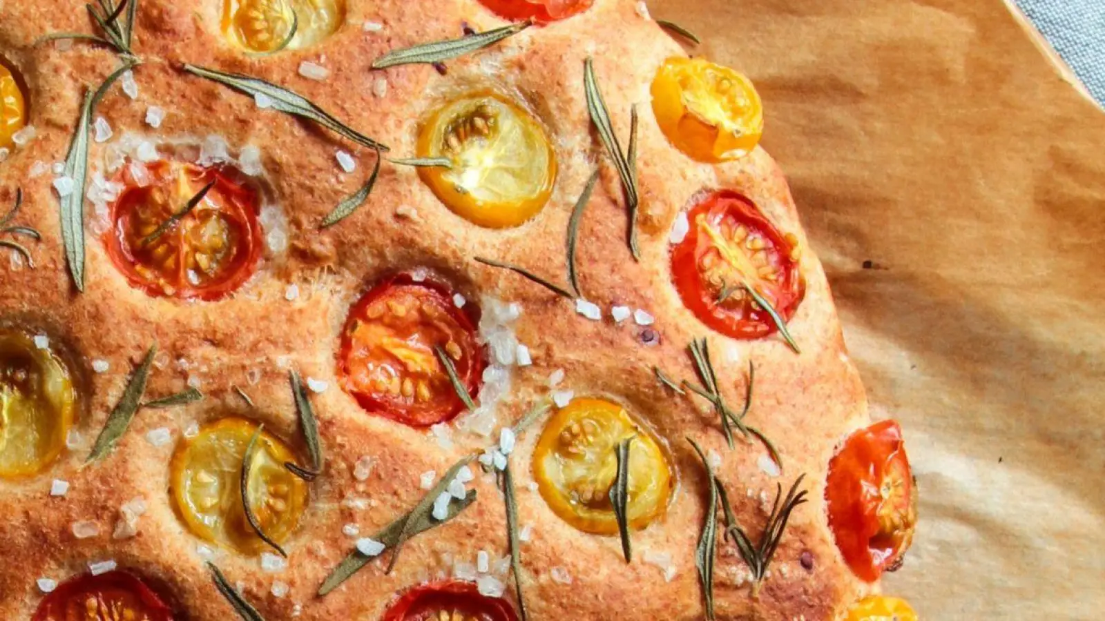 Ein lockerer Hefeteig, der sich nach Lust und Laune belegen lässt: Hier wird die Focaccia ganz klassisch von Tomaten und Rosmarin gekrönt. (Foto: Aileen Kapitza/minzgruen.com/dpa)