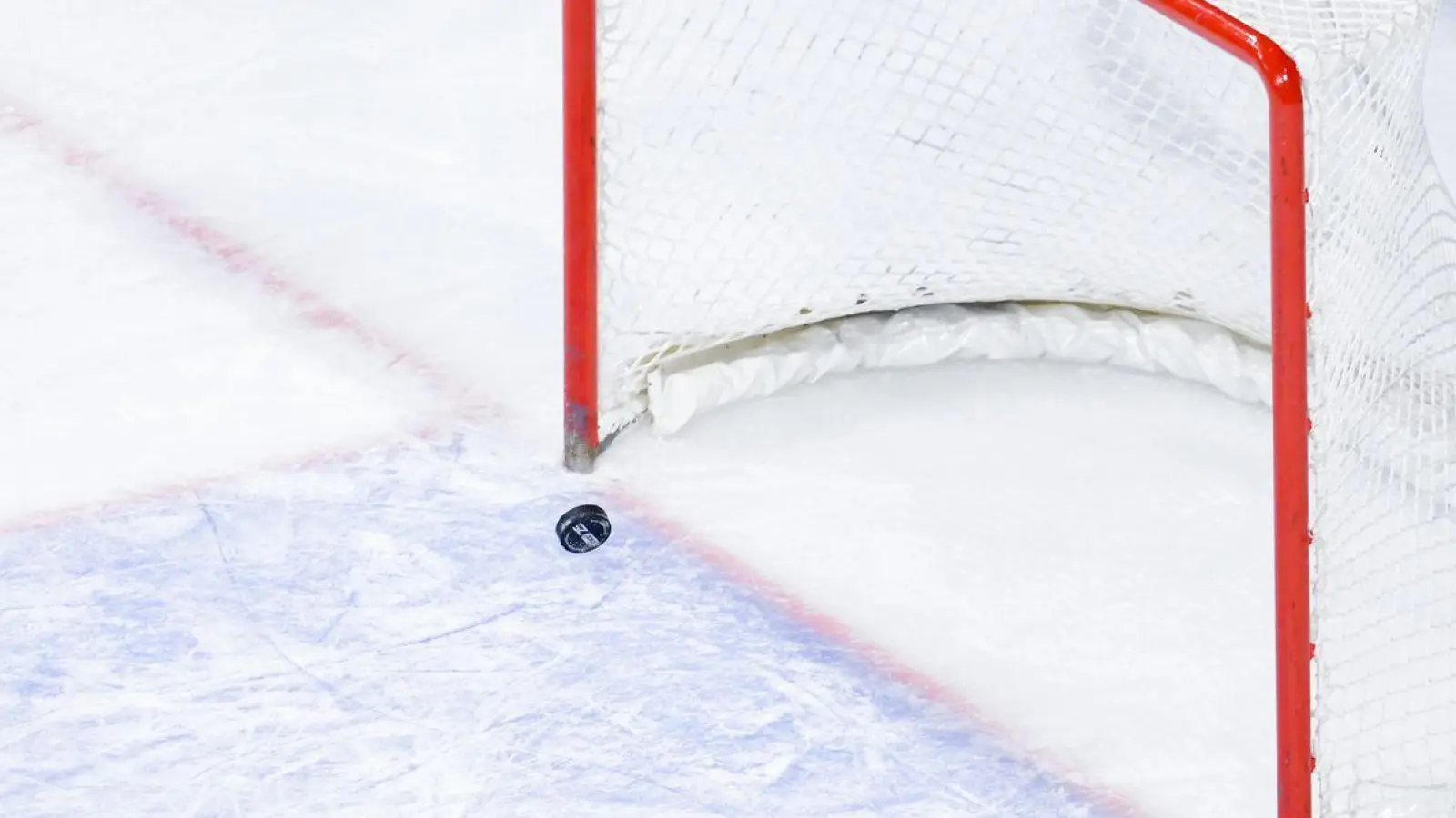 Ein Puck fliegt in ein leeres Eishockey-Tor. (Foto: Uwe Anspach/Deutsche Presse-Agentur GmbH/dpa/Symbolbild)