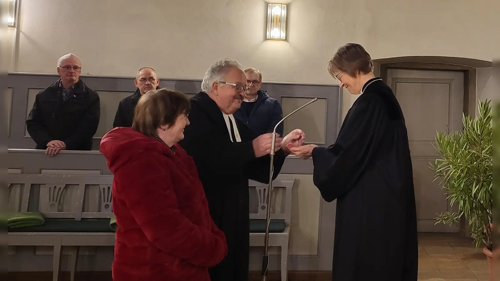 Hermann Rummel mit seiner Frau Renate bei der feierlichen Entpflichtung durch Regionalbischöfin Gisela Bornowski, der er sein Amtskreuz zurückgab. (Foto: Albert Schülein)