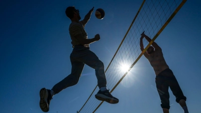Im Englischen Garten wurde am Freitag bei frühlingshaftem Wetter und strahlendem Sonnenschein schon Volleyball gespielt. (Foto: Peter Kneffel/dpa)