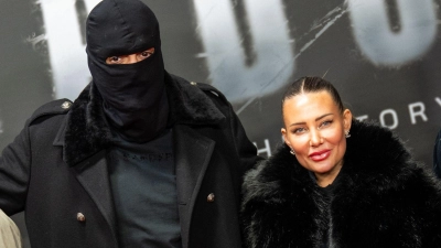 Haftbefehl (bürgerlich Aykut Anhan und hier verhüllt) besucht mit seiner Frau Nina Anhan eine Kinoaufführung der Dokumentation „Babo - Die Haftbefehl-Story“ in Berlin. (Archivbild) (Foto: Christophe Gateau/dpa)