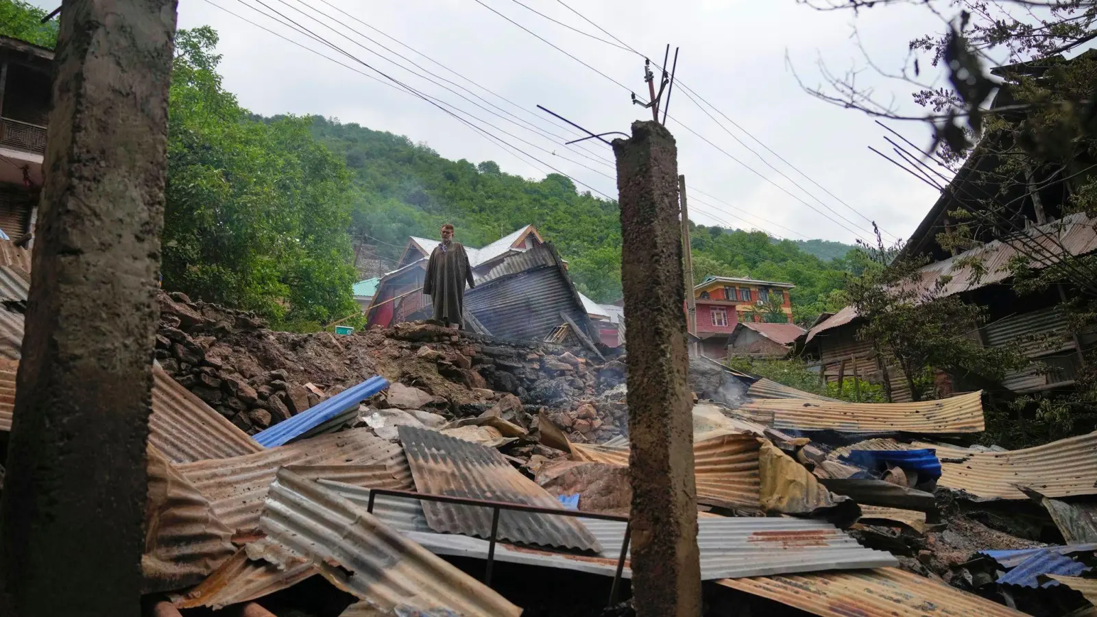 Ein Mann inspiziert sein beschädigtes Haus nach dem nächtlichen Beschuss aus Pakistan im Dorf Gingal im Bezirk Uri im indisch kontrollierten Kaschmir. (Foto: Dar Yasin/AP/dpa)