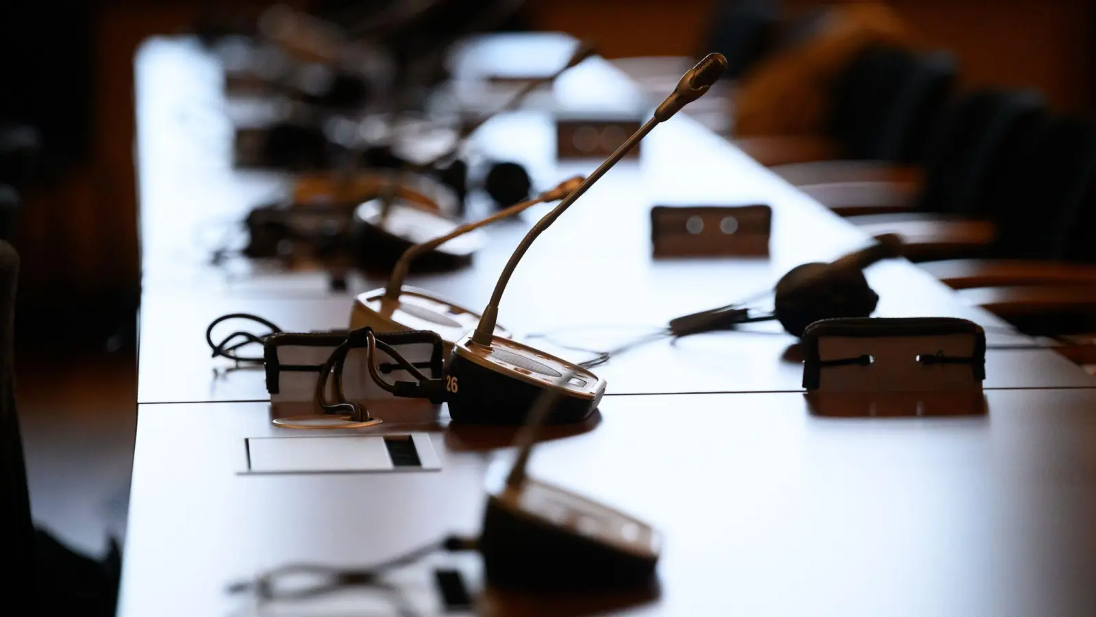 Mikrofone und Kopfhörer auf einem Tisch in einem Gerichtssaal. (Foto: Jonas Walzberg/dpa/Symbolbild)