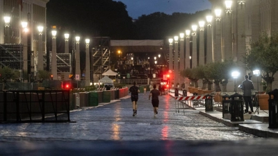 Konklave zur Wahl eines neuen Papstes: Menschen joggen am Morgen des zweiten Tages des Konklaves zur Wahl eines neuen Papstes über die Via della Conciliazione in der Nähe des Petersplatzes. (Foto: Marijan Murat/dpa)