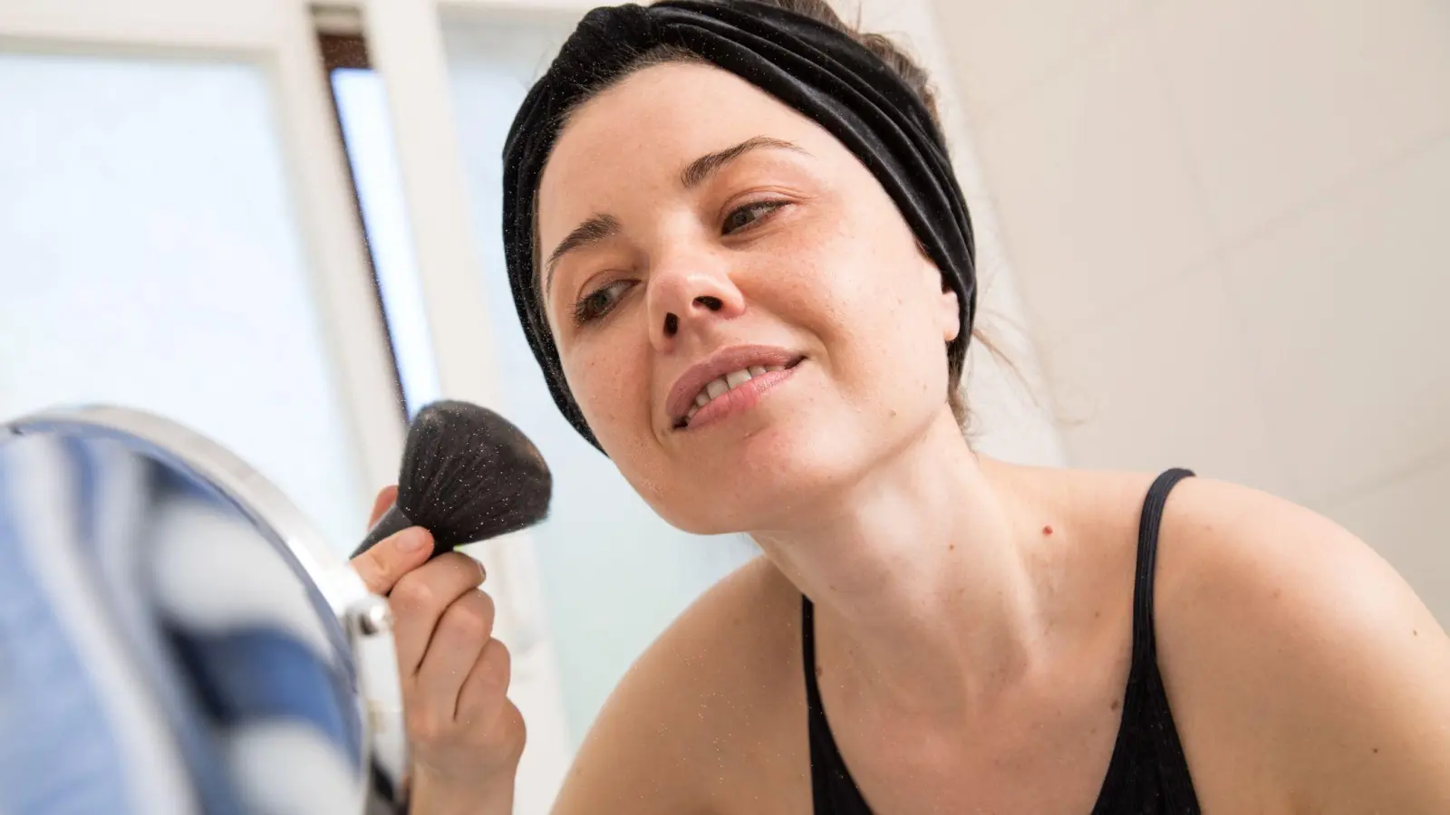 Wer bei schweißtreibenden Temperaturen nicht aufs Make-up verzichten mag, sollte auf wasserfeste Wimperntusche und mattierendes Puder setzen. So lässt sich verhindern, dass die Schminke schnell verläuft. (Foto: Christin Klose/dpa-tmn)