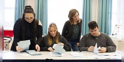 Zum Juniorwahl-Projekt gehören alle Handgriffe, die bei einer Wahl nötig sind. Auch das Auszählen liegt in Schülerhänden, hier am BSZ in Scheinfeld von Amanda Andriuzzi, Eva-Marie Schmidt und Maximilian Schotzer (von links) unter den Augen von Lehrerin Carina Härth. (Foto: BSZ/Tobias Völker)