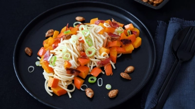 Eine ganze Knolle Knoblauch wird für die Herbst-Pasta zusammen mit dem Kürbis gebacken. So bekommt man eine tolle Karamellnote. (Foto: Julia Uehren/loeffelgenuss.de/dpa-tmn)