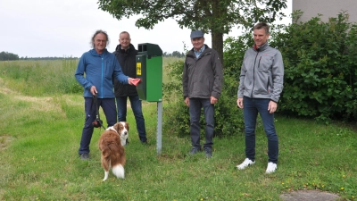 Matthias Kriesl (von links), Thomas Deffner, Gerhard Sauerhammer und Martin Waldmann an einem der drei Beutelspender in Strüth. (Foto: Jonas Volland)