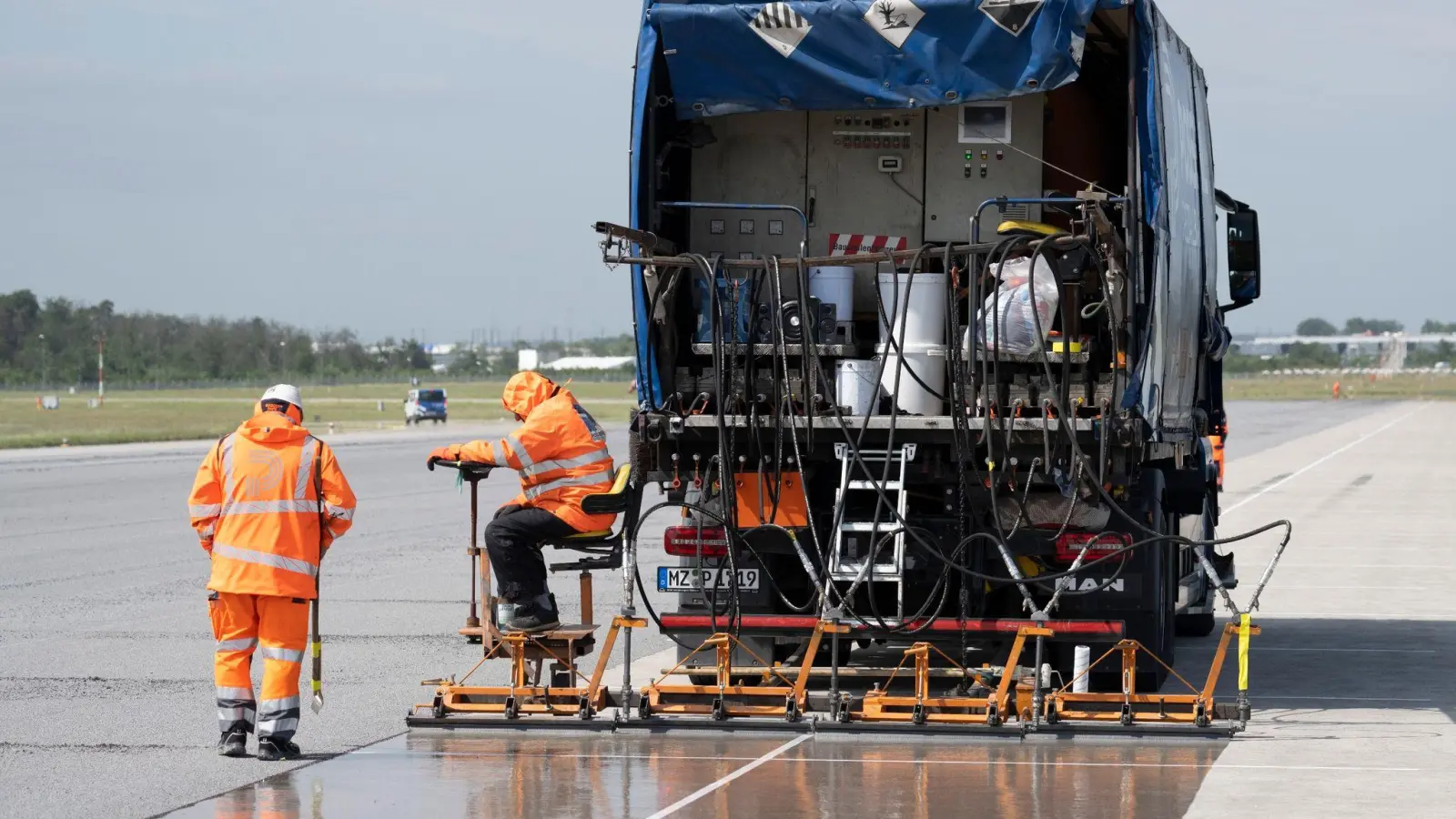 Eine spezielle Flüssig-Grundierung bringen Arbeiter mit einem Spezialfahrzeug auf der Landebahn Nordwest auf dem Flughafen in Frankfurt an. Am Frankfurter Flughafen hat der Betreiber Fraport die frisch sanierte Landebahn Nordwest nach wenigen Betriebsstunden wieder gesperrt. (Foto: Boris Roessler/dpa)
