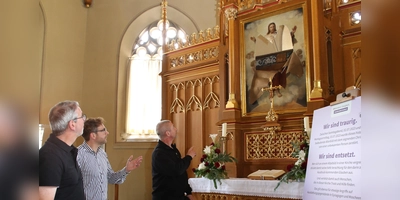 In der Heilig-Kreuz-Kirche beratschlagen Dekan Dr. Matthias Büttner, Frank Weihermann von der Gesamtkirchengemeinde und Pfarrer Hermann Spingler wegen des Schadens (von links). (Foto: Alexander Biernoth)