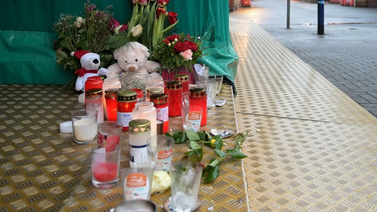 Menschen haben Blumen, Kerzen und Plüschtiere niedergelegt. (Foto: Heiko Rebsch/dpa)