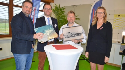 Zeigten bei der Jubiläumsveranstaltung Bilder aus der 100-jährigen Firmen-Geschichte: Rainer Wettemann (Zweiter von rechts) und Bürgermeister Michael Sommer (Zweiter von links) zusammen mit Heike Wagner von der Buchhaltung und Vertriebsmitarbeiter Savas Tuncelli. (Foto: Peter Tippl)