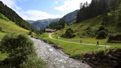 Ausflügler wandern im Rappenalptal entlang des Rappenalpbaches unter teilweise Bewölktem Himmel. (Foto: Karl-Josef Hildenbrand/dpa)