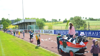 Über viele Meter hinweg standen die Kinder der Kita Diespeck auf der Laufbahn des Sportgeländes und hielten ihre selbst gebastelten Wimpel hoch. (Foto: Christa Frühwald)