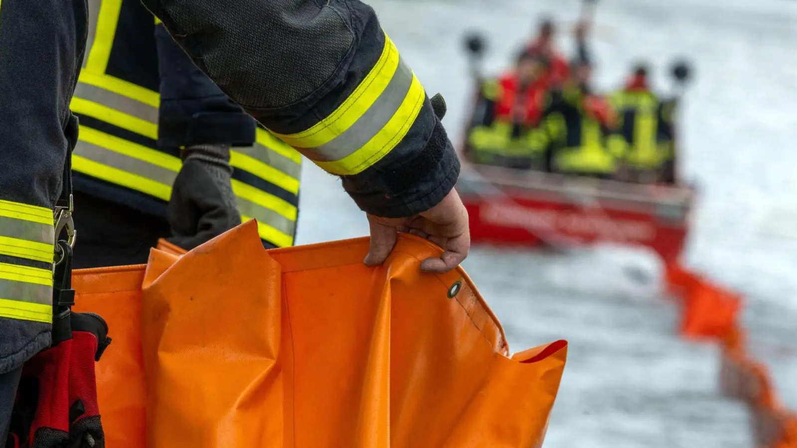 Feuerwehrleute errichten auf der Donau eine Ölsperre. (Symbolbild) (Foto: Pia Bayer/dpa)