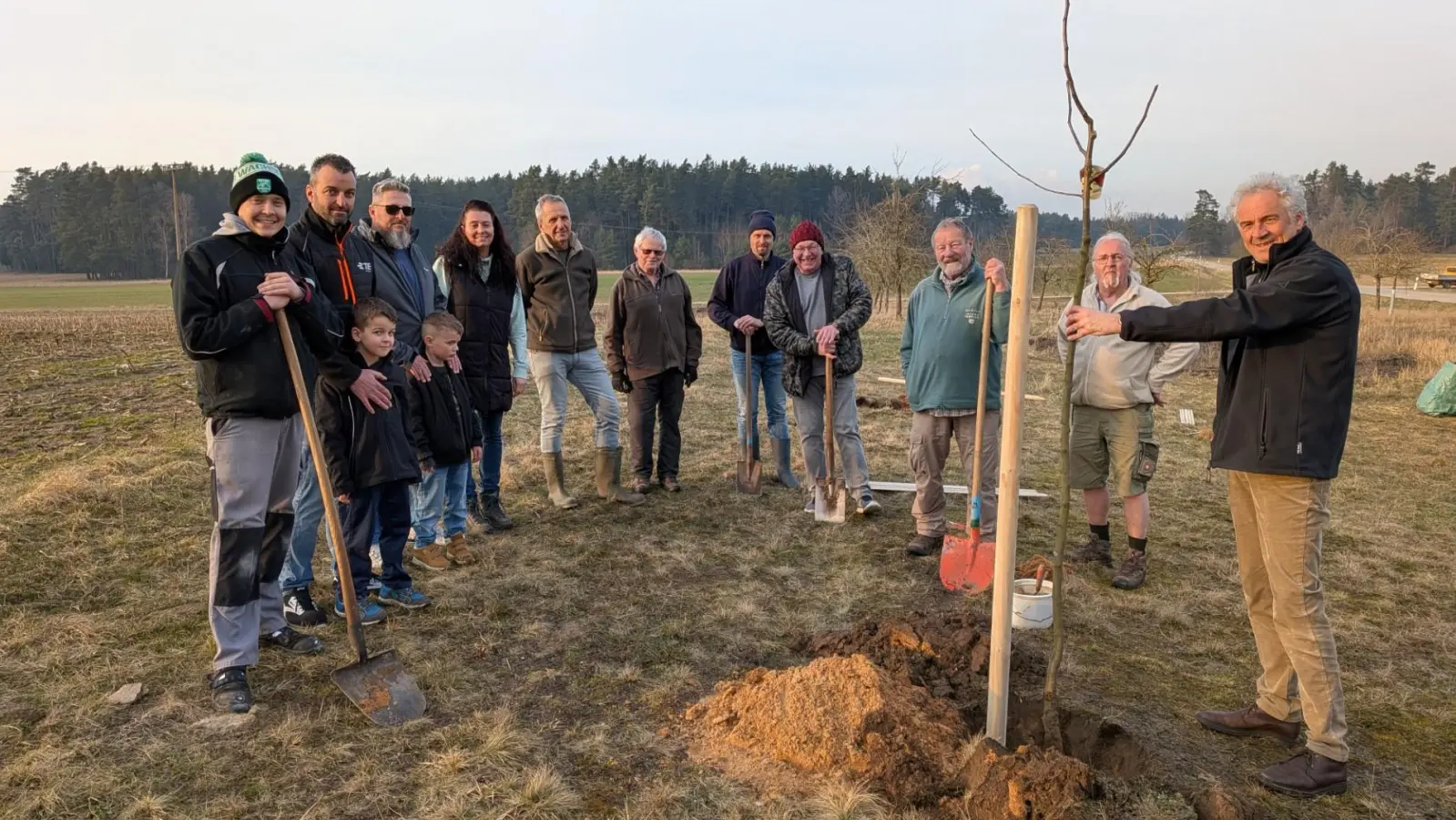 Norbert Metz (rechts) vom LPV erläutert den Aktiven des Obst- und Gartenbauvereins Burk mit Vorsitzendem Christoph Weber (3. von rechts) die fachgerechte Pflanzung. (Foto: Friedrich Zinnecker)