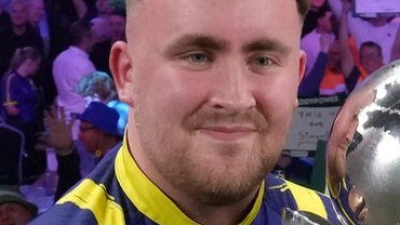 Littler präsentiert zum zweiten Mal die WM-Trophäe. (Foto: Dave Shopland/AP/dpa)