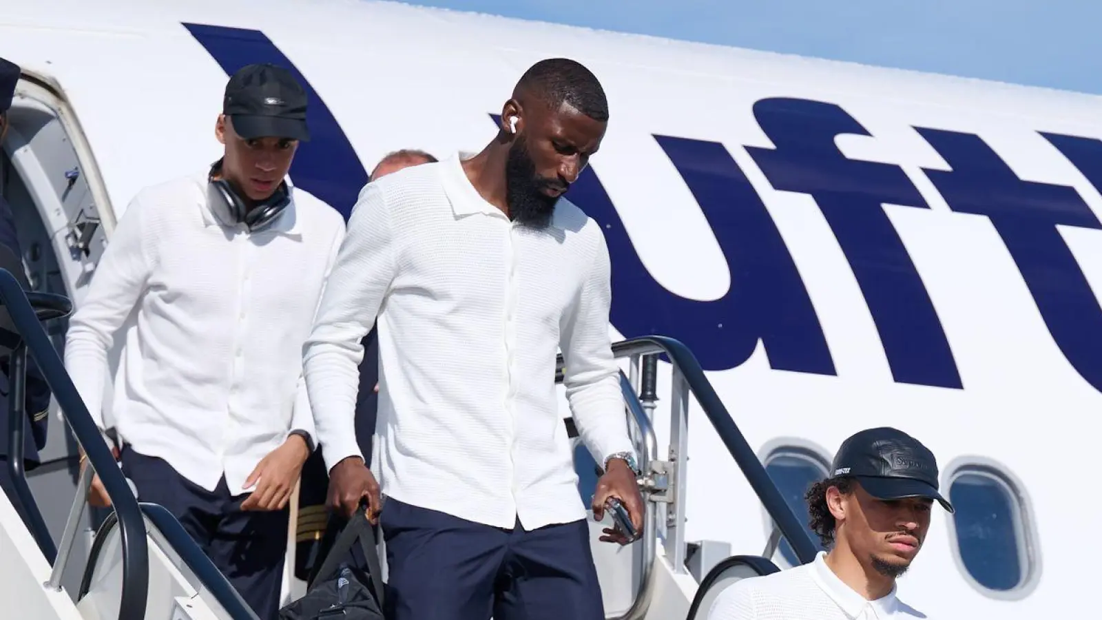 Die deutsche Fußballnationalmannschaft kommt in Dortmund an, um morgen das EM-Achtelfinale gegen Dänemark zu bestreiten. Jamal Musiala (l-r), Antonio Rüdiger, Leroy Sane und Thomas Müller steigen hier aus der Maschine. (Foto: Bernd Thissen/dpa)