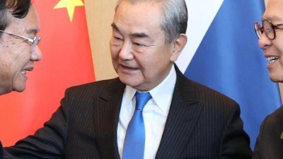 Der kambodschanische Außenminister Prak Sokhonn (l) schüttelt die Hand seines thailändischen Amtskollegen Sihasak Phuangketkeow (r) vor dem chinesischen Amtskollegen Wang Yi. (Foto: Uncredited/Agence Kampuchea Press/AP/dpa)