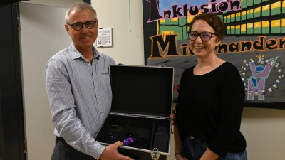 Schulleiter Markus Heindl und Simone Thiel vom Elternbeirat präsentieren einen der Koffer, in denen die Smartphones während des Unterrichts verstaut werden. (Foto: Luca Paul)