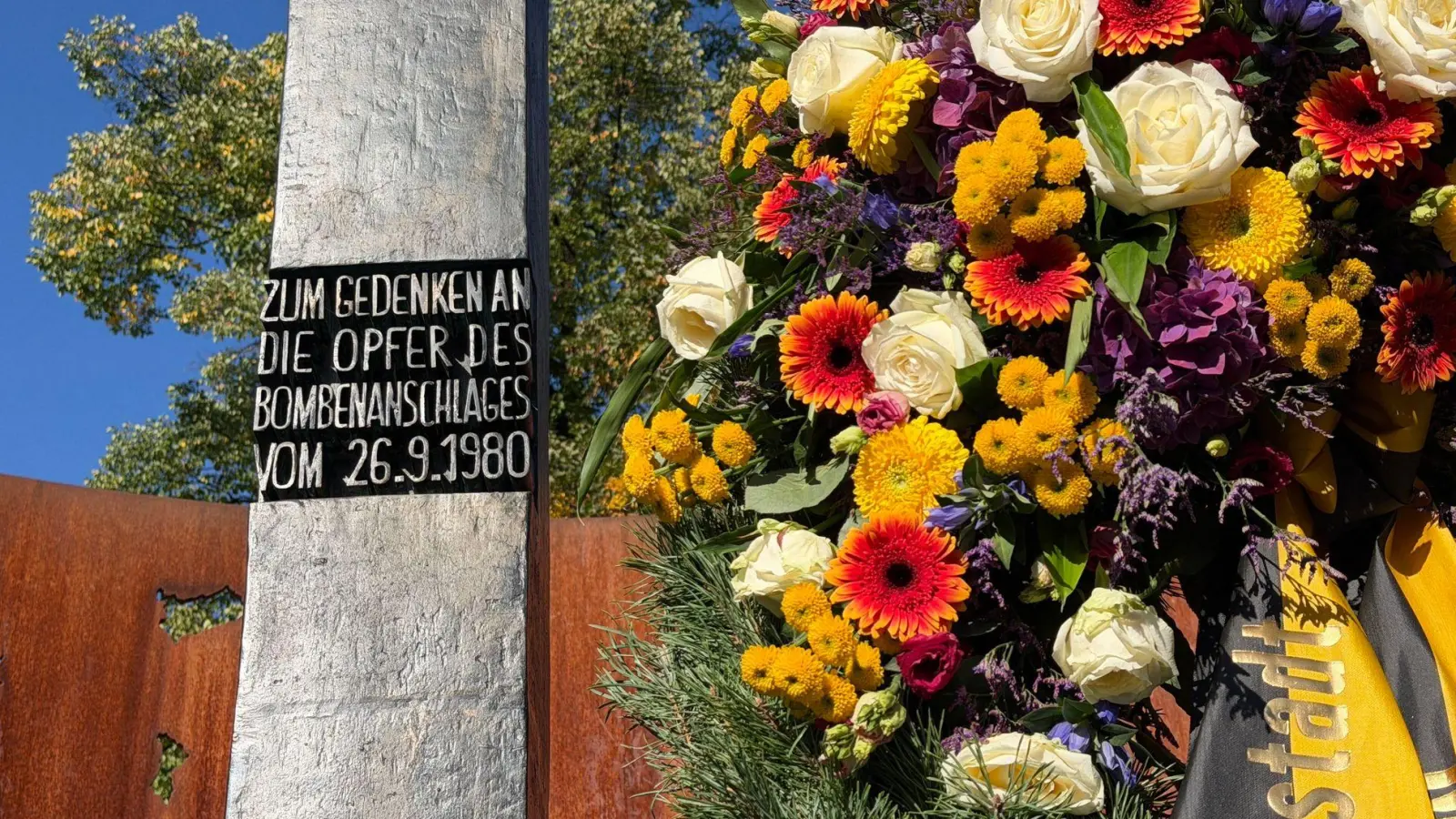 Ein Blumengesteck am Denkmal erinnert an die Opfer des Oktoberfest-Attentats. (Foto: Julian Degler/dpa)