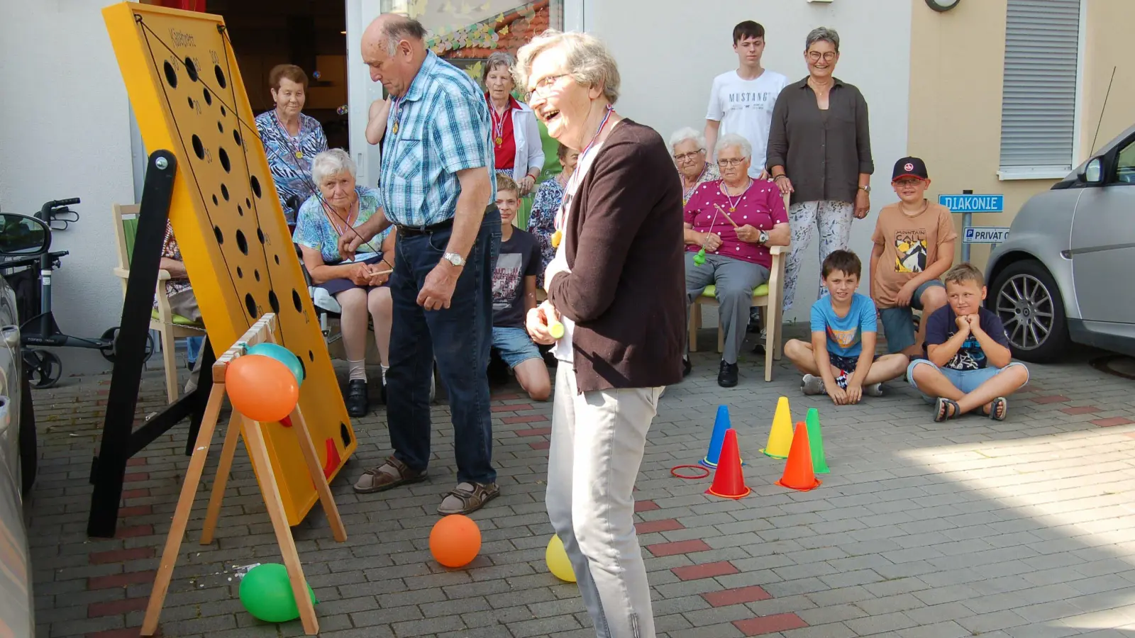 Hartmut Lunz testete seine Geschicklichkeit am Käsebrett. Auch Marga Weninger freute sich über die Aktivitäten bei der Seniorenolympiade vor dem Haus der Tagespflege. (Foto: Christa Frühwald)