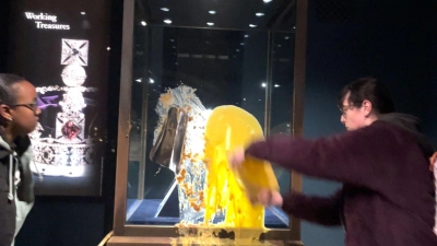 Aktivisten beschmieren die Vitrine, in der die Krone ist. (Foto: Take Back Power/PA Media/dpa)
