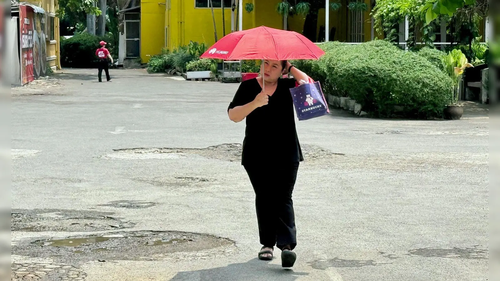 Viele schützen sich mit Schirmen vor der Sonne. (Foto: Carola Frentzen/dpa)