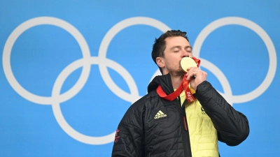 Der 35-jährige Rodler Johannes Ludwig feiert mit seiner Goldmedaille auf dem Podium. (Foto: Robert Michael/dpa-Zentralbild/dpa)