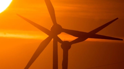 Die Sonne geht hinter Windrädern auf. (Foto: Julian Stratenschulte/dpa/Symbolbild)