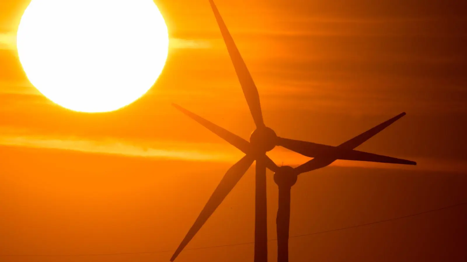 Die Sonne geht hinter Windrädern auf. (Foto: Julian Stratenschulte/dpa/Symbolbild)