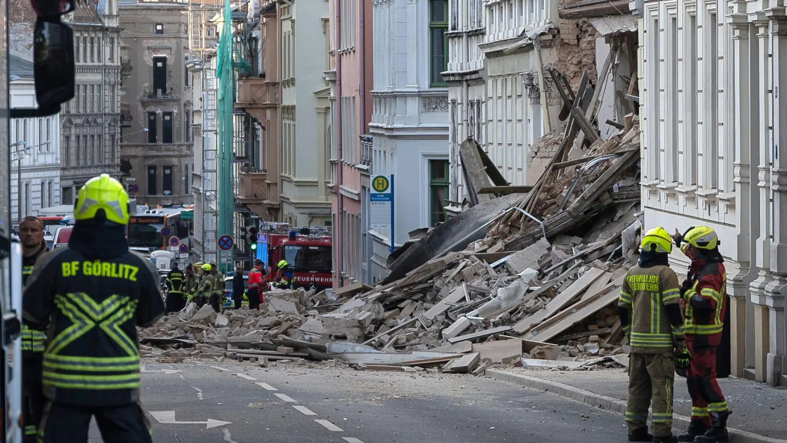 Einsatzkräfte von Polizei und Feuerwehr stehen in der Nähe eines eingestürzten Hauses in Görlitz. Als Ursache vermutet man eine Gasexplosion. (Foto: Paul Glaser/dpa/dpa-tmn)