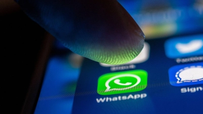 Ein Finger berührt das WhatsApp-Logo auf einem Smartphone. (Foto: Zacharie Scheurer/dpa)