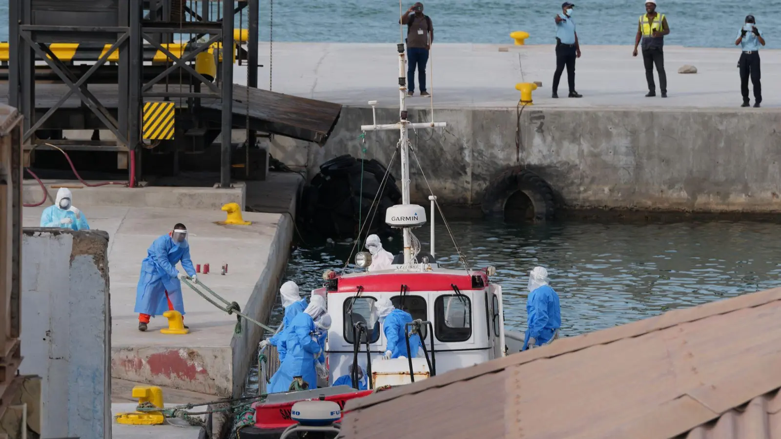 Gesundheitspersonal in Schutzkleidung evakuiert Patienten vom Kreuzfahrtschiff „Hondius“ in einem Hafen.  (Foto: Misper Apawu/AP/dpa)