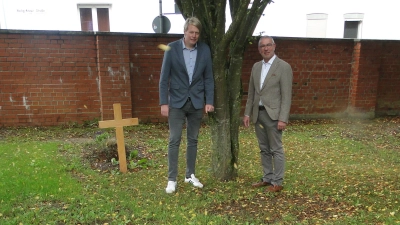 Dekan Dr. Matthias Büttner (rechts) und der stellvertretende Geschäftsführer der Gesamtkirchengemeinde, Manuel Dornhöfer, am Rasenfeld, das für die Urnenbestattung unter Bäumen vorgesehen ist. (Foto: Winfried Vennemann)