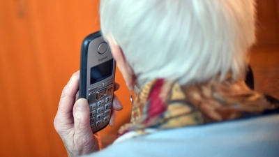 Eine Seniorin hält einen Telefonhörer an ihr Ohr. Laut einer Umfrage von 2021 fühlt sich jeder fünfte Mensch über 75 Jahren häufig oder zumindest hin und wieder einsam. (Foto: Britta Pedersen/dpa-Zentralbild/dpa/Symbolbild)