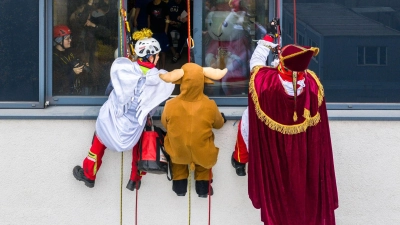 Verkleidete Höhenretter seilen sich von einem Gebäude des Herzzentrums Duisburg ab, um kleinen Patienten im Kinderherzzentrum Geschenke zu bringen. (Foto: Christoph Reichwein/dpa)