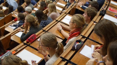 Studenten und Studentinnen verfolgen eine Vorlesung. (Foto: Swen Pförtner/dpa)